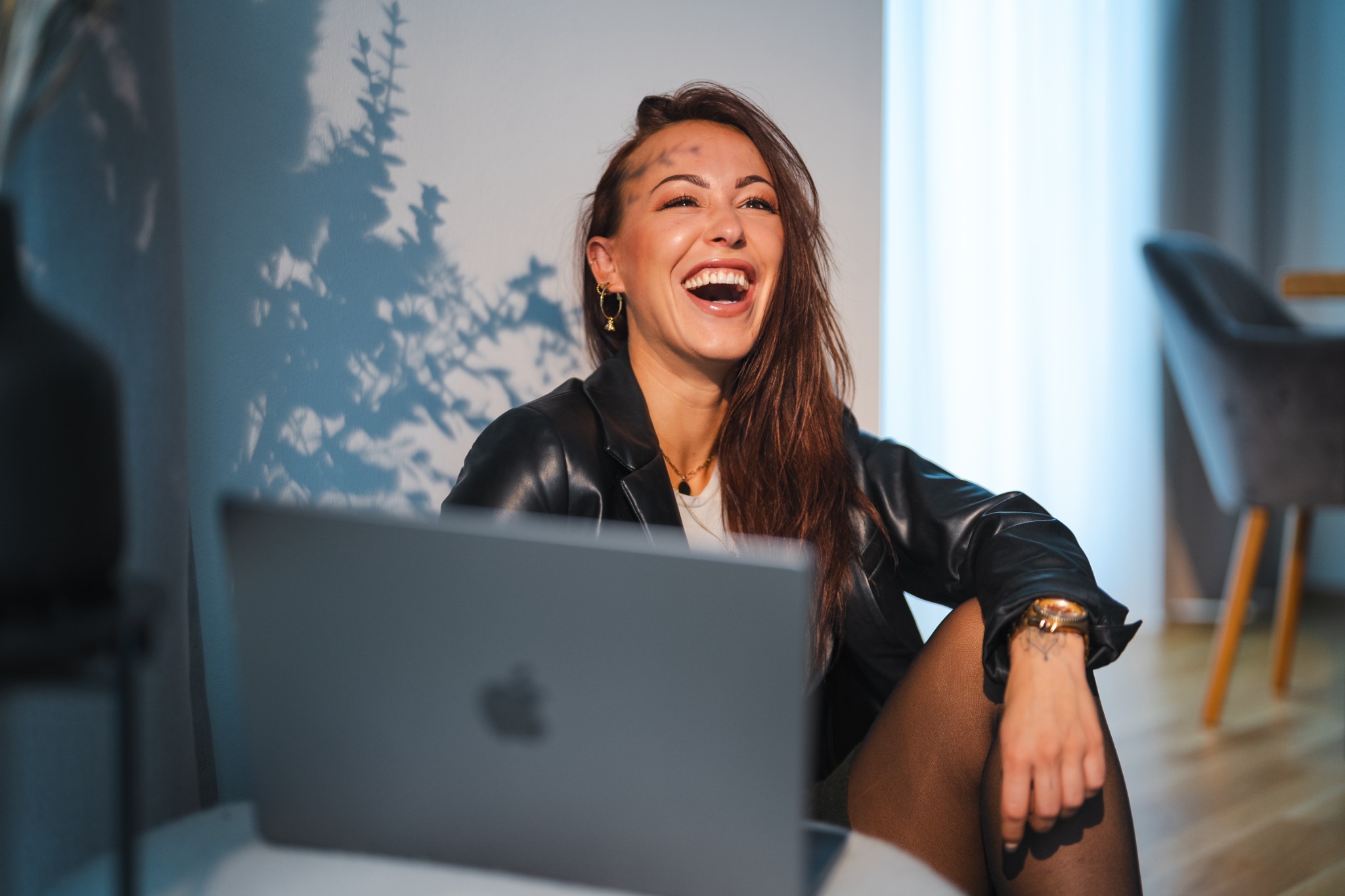 Lara lacht während der Arbeit am Laptop